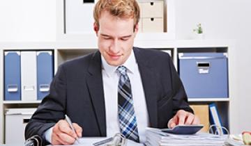 Man Calculating at Desk