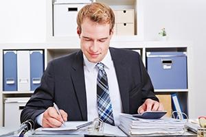 Man Calculating at Desk